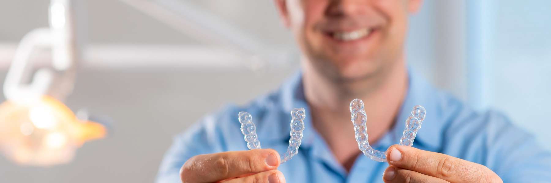 Dentist holding Invisalign clear aligners in Oatley, NSW