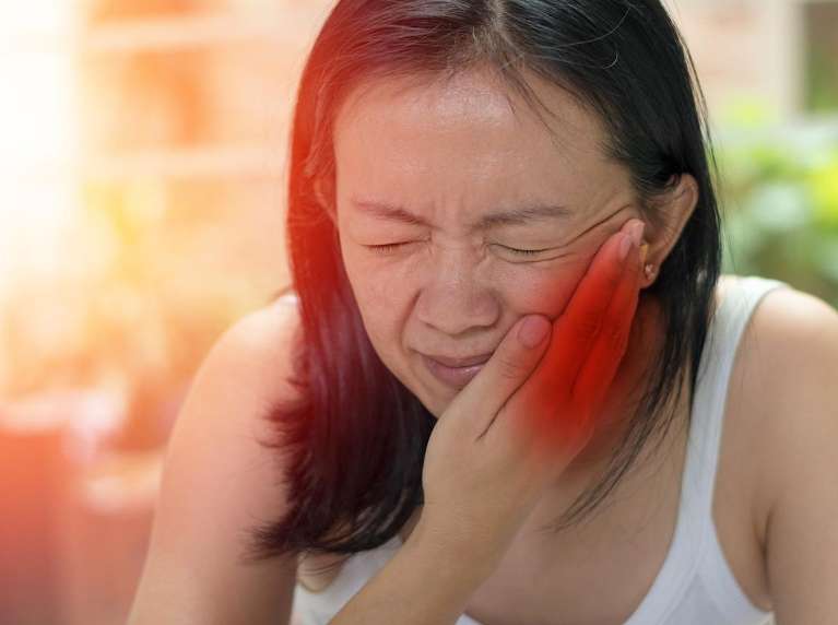A lady holding her jaws due to root canal in Oatley, NSW.