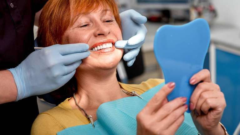 Lady looking herself in the mirror during dental examination in Oatley, NSW